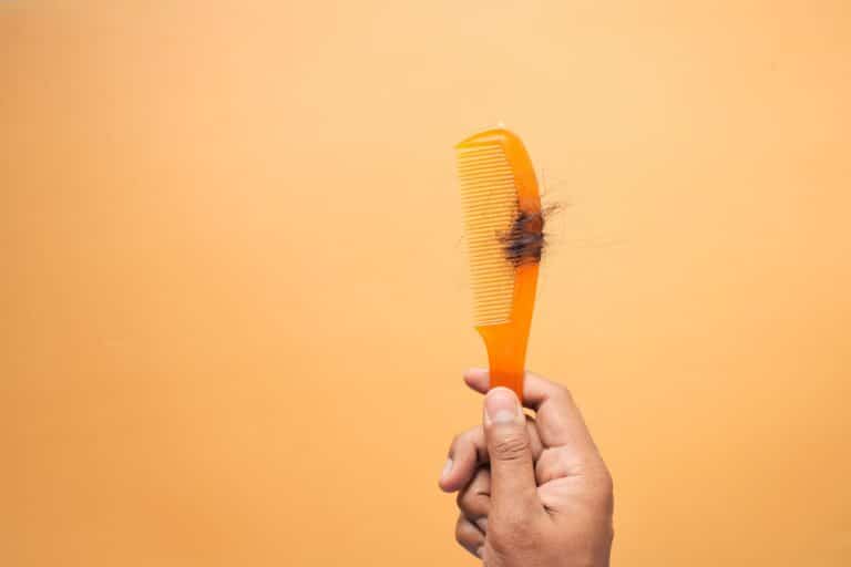 Orange comb with clump of hair