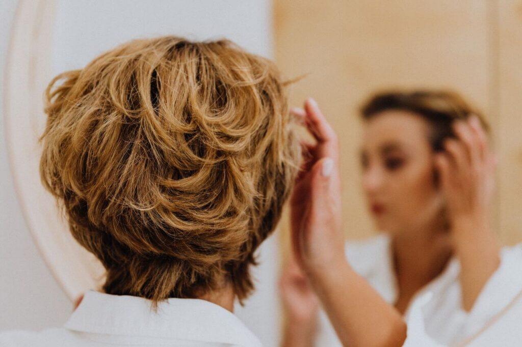 Woman with blond hair looking in the mirror