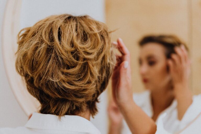 Woman with blond hair looking in the mirror